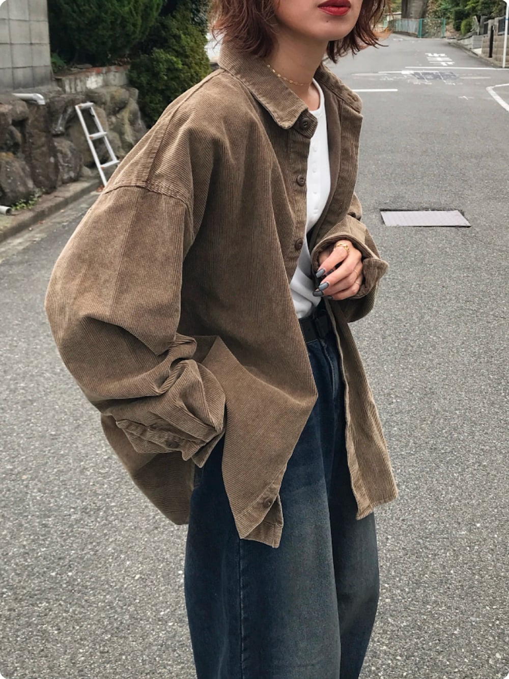 ブラック系のブーツ、ブラック系のハンドバッグ、ブラウン系のシャツ/ブラウスを着用したレディースの秋コーディネートの2枚目の写真