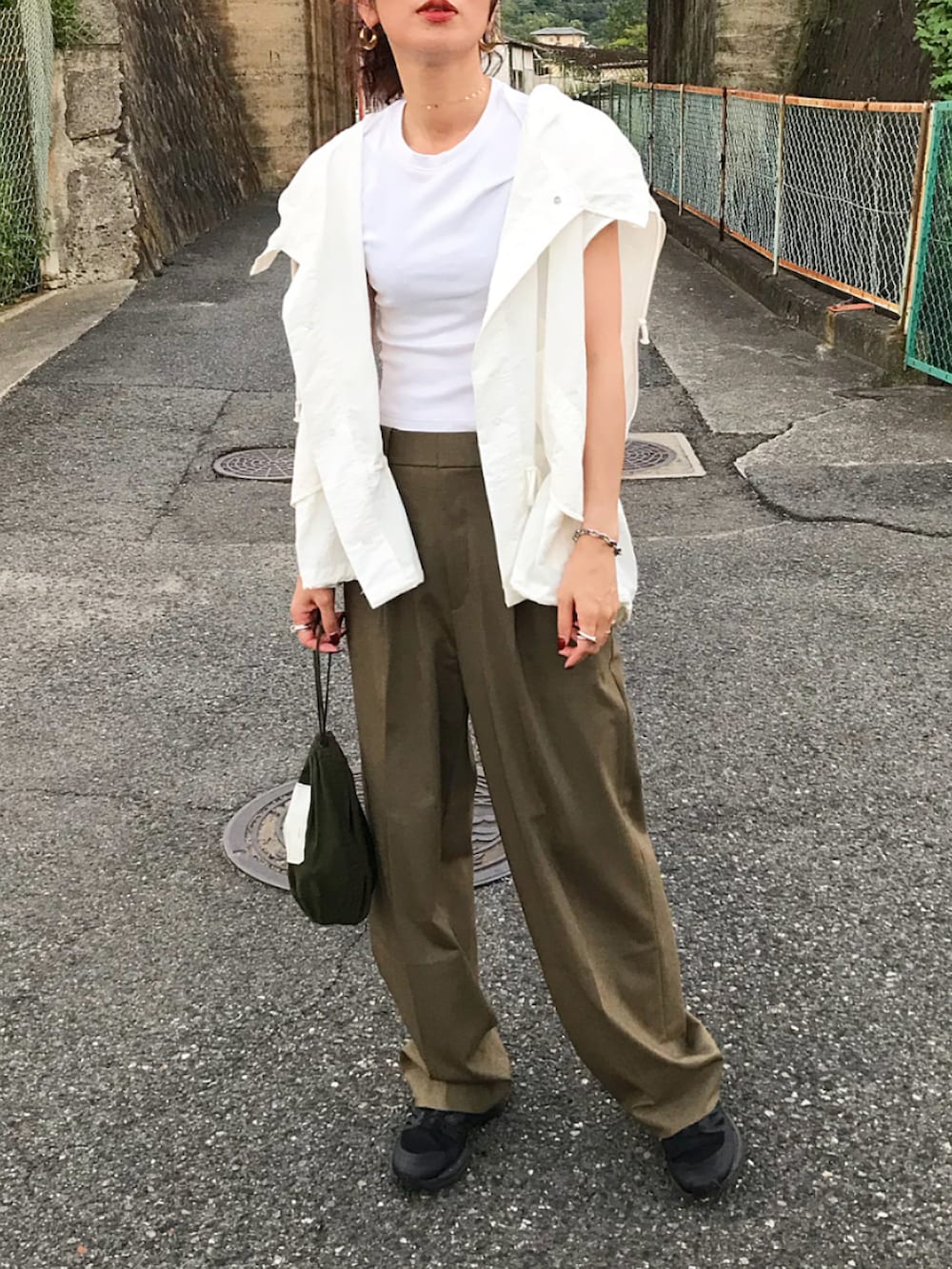 ホワイト系のベスト、ホワイト系のTシャツ/カットソー、ベージュ系のパンツを着用したレディースの夏コーディネートの2枚目の写真