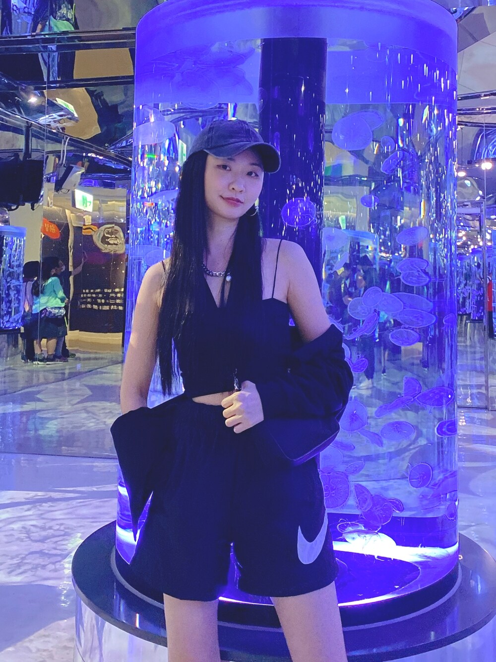 ブラック系のカーゴパンツ、ブラック系のキャミソール、ベージュ系のスニーカーを着用したレディースの秋コーディネートの2枚目の写真