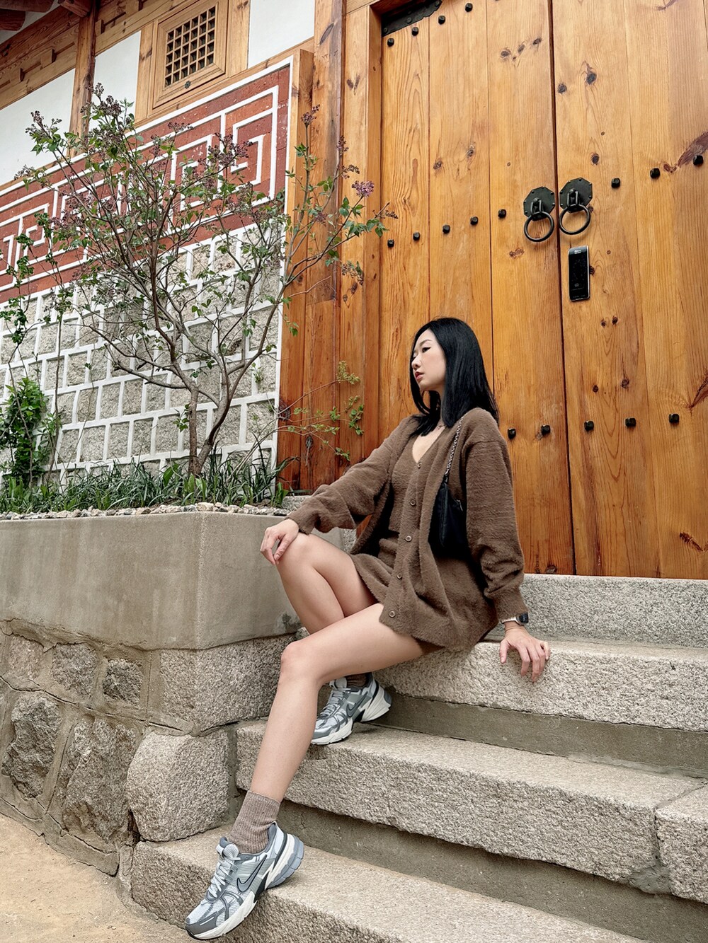 シルバー系のスニーカー、ブラウン系のキャミソール、ブラック系のショルダーバッグを着用したレディースの春コーディネートの2枚目の写真