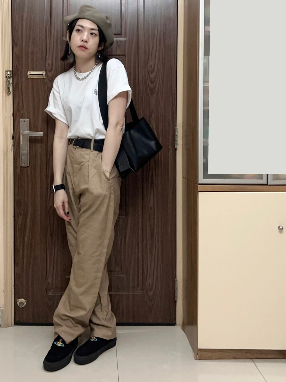 ベージュ系のテーラードジャケット、ホワイト系のTシャツ/カットソー、ベージュ系のスラックスを着用したレディースの夏コーディネートの2枚目の写真