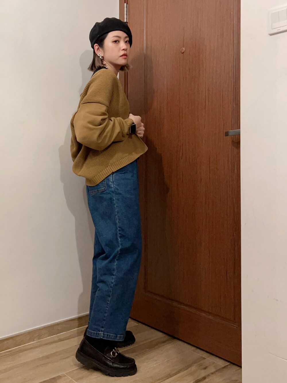 ブラック系のタンクトップ、ベージュ系のジャケット/アウター、ブルー系のデニムパンツを着用したレディースの秋コーディネートの3枚目の写真