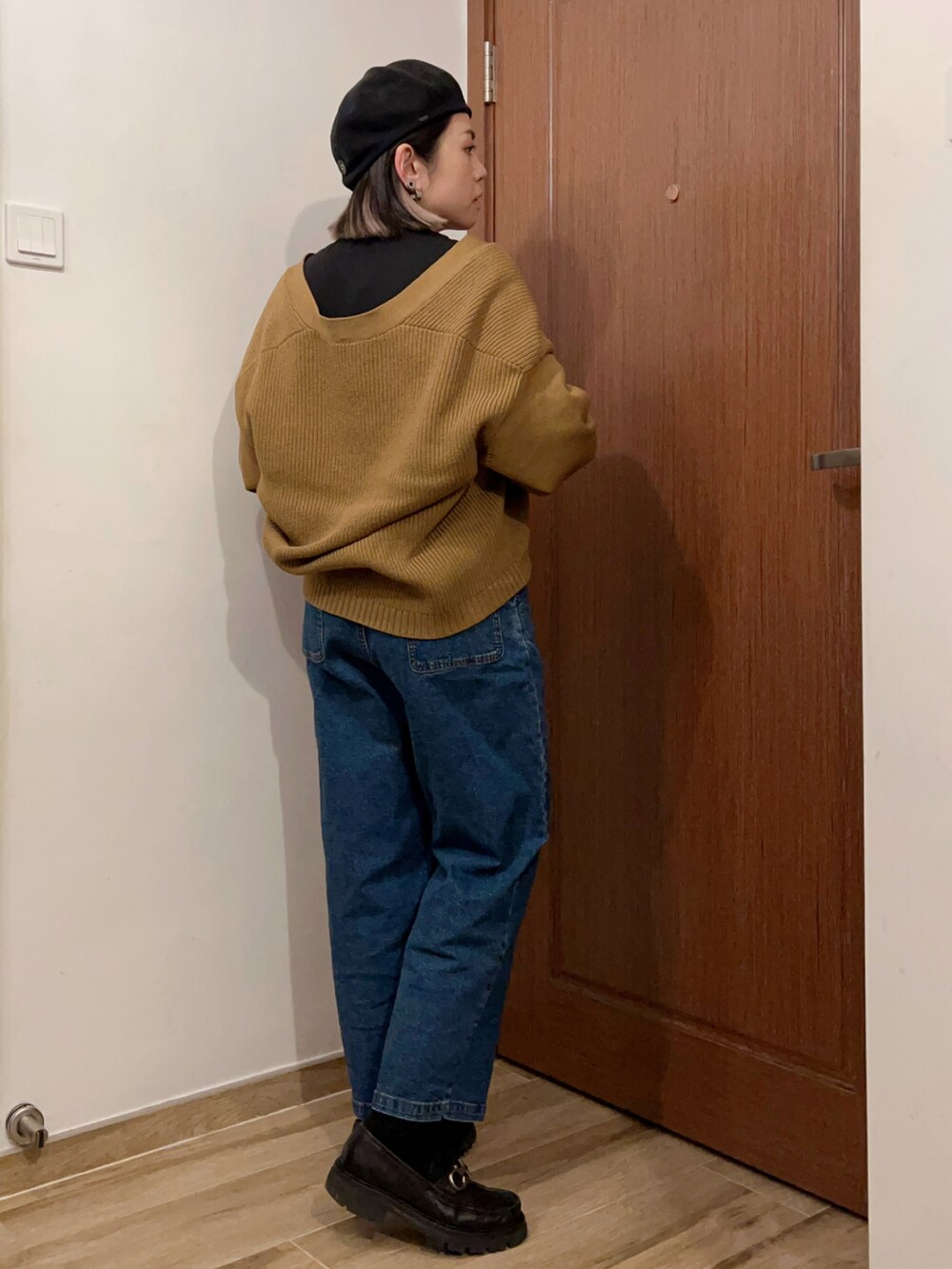 ブラック系のタンクトップ、ベージュ系のジャケット/アウター、ブルー系のデニムパンツを着用したレディースの秋コーディネートの4枚目の写真