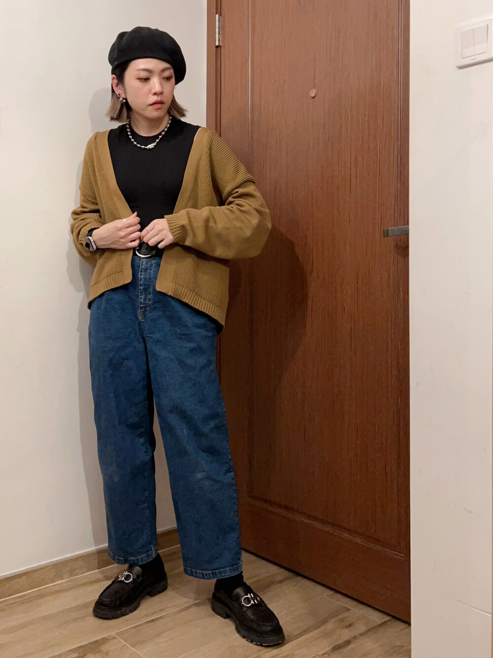 ブラック系のタンクトップ、ベージュ系のジャケット/アウター、ブルー系のデニムパンツを着用したレディースの秋コーディネートの2枚目の写真