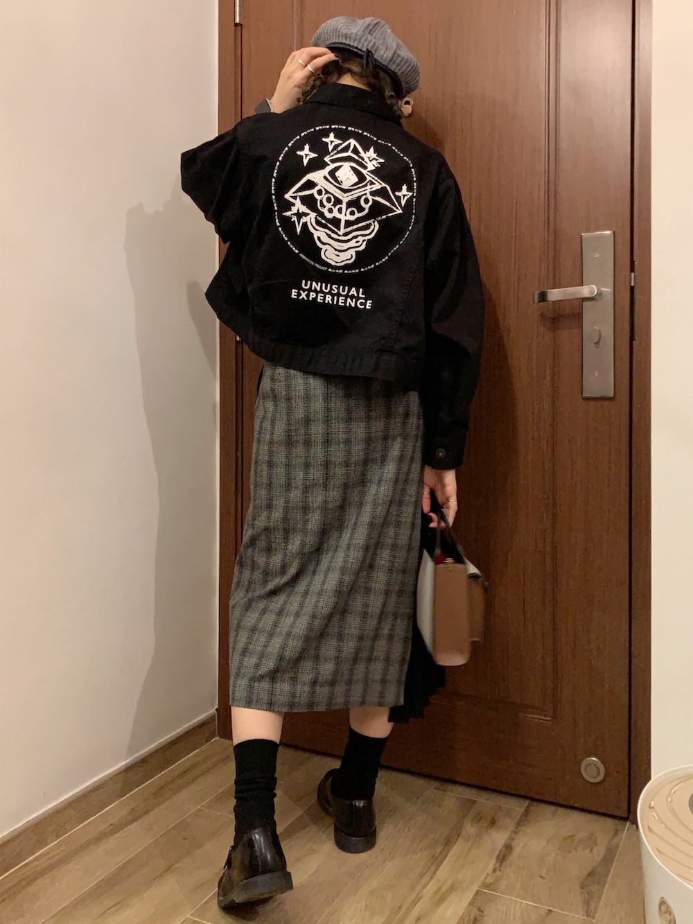 ブラック系のジャケット/アウター、ブラウン系のTシャツ/カットソー、グレー系のスカートを着用したレディースの秋コーディネートの2枚目の写真