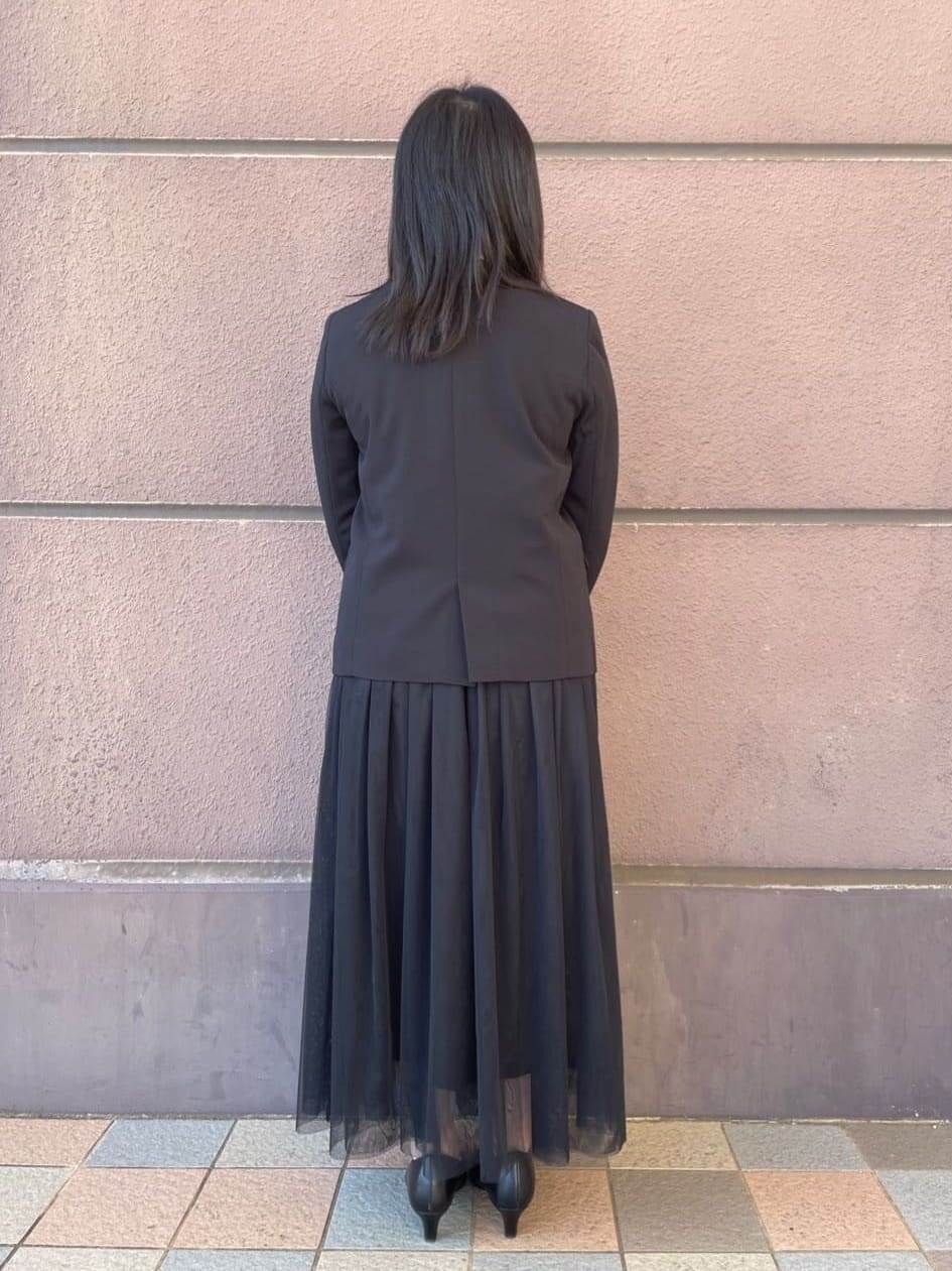 ブラック系のノーカラージャケット、ブラック系のスカート、ブラック系のパンプスを着用したレディースの冬コーディネートの3枚目の写真