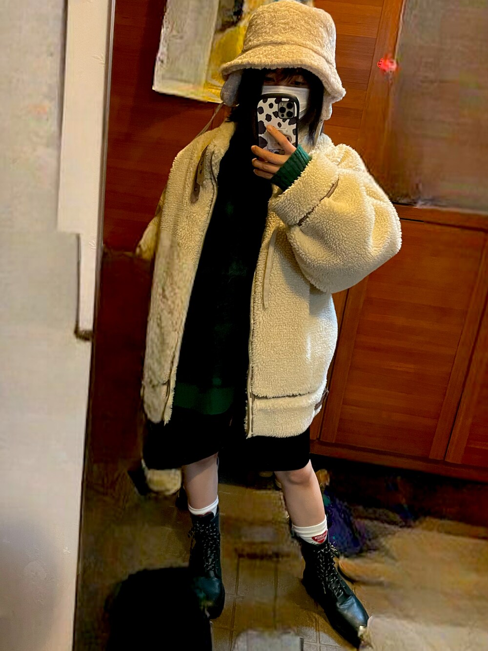 グリーン系のニット/セーター、グリーン系のブーツ、ホワイト系のハットを着用したレディースの冬コーディネートの2枚目の写真