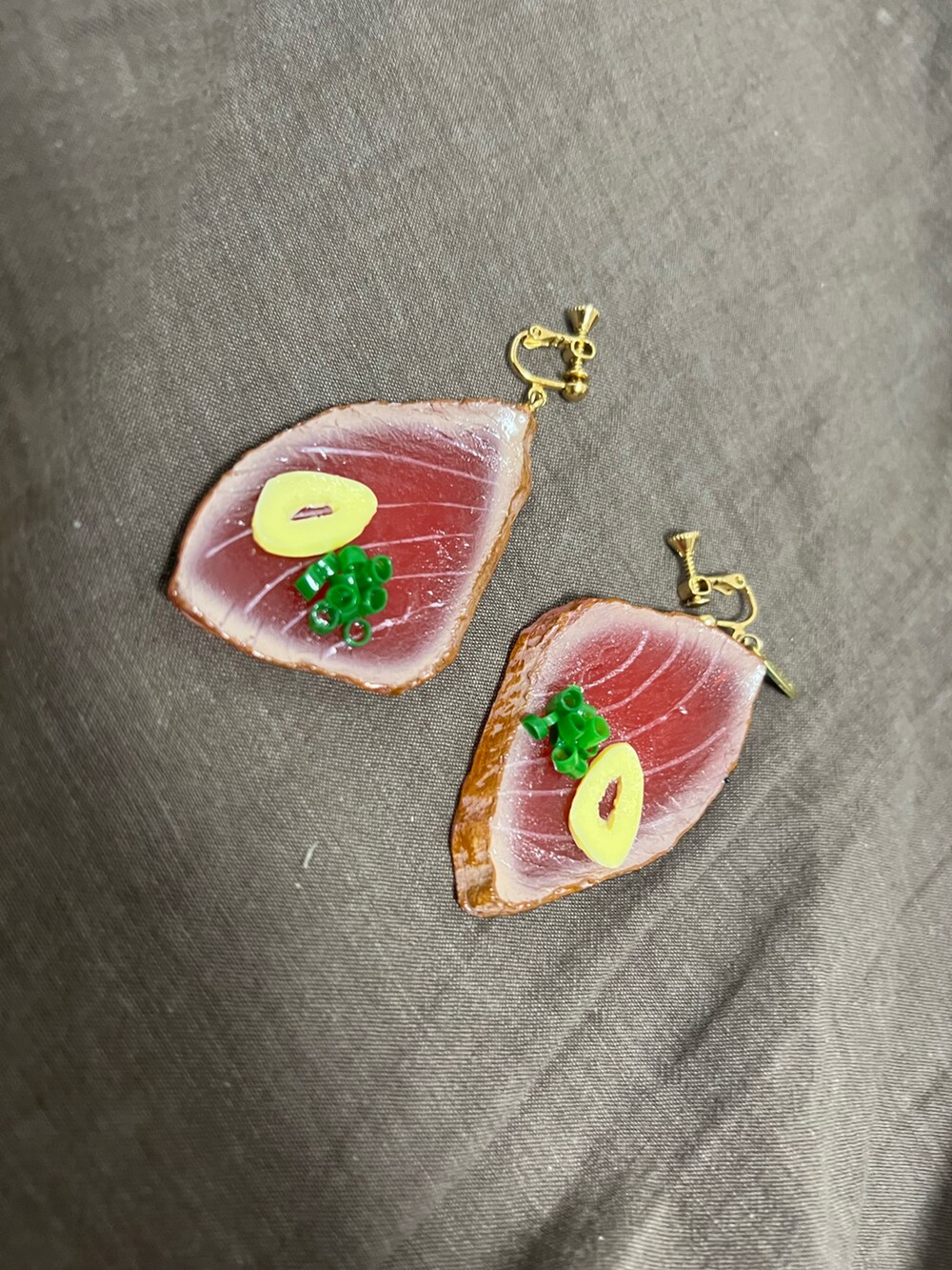 レッド系のイヤリングを着用したレディースの秋コーディネートの2枚目の写真