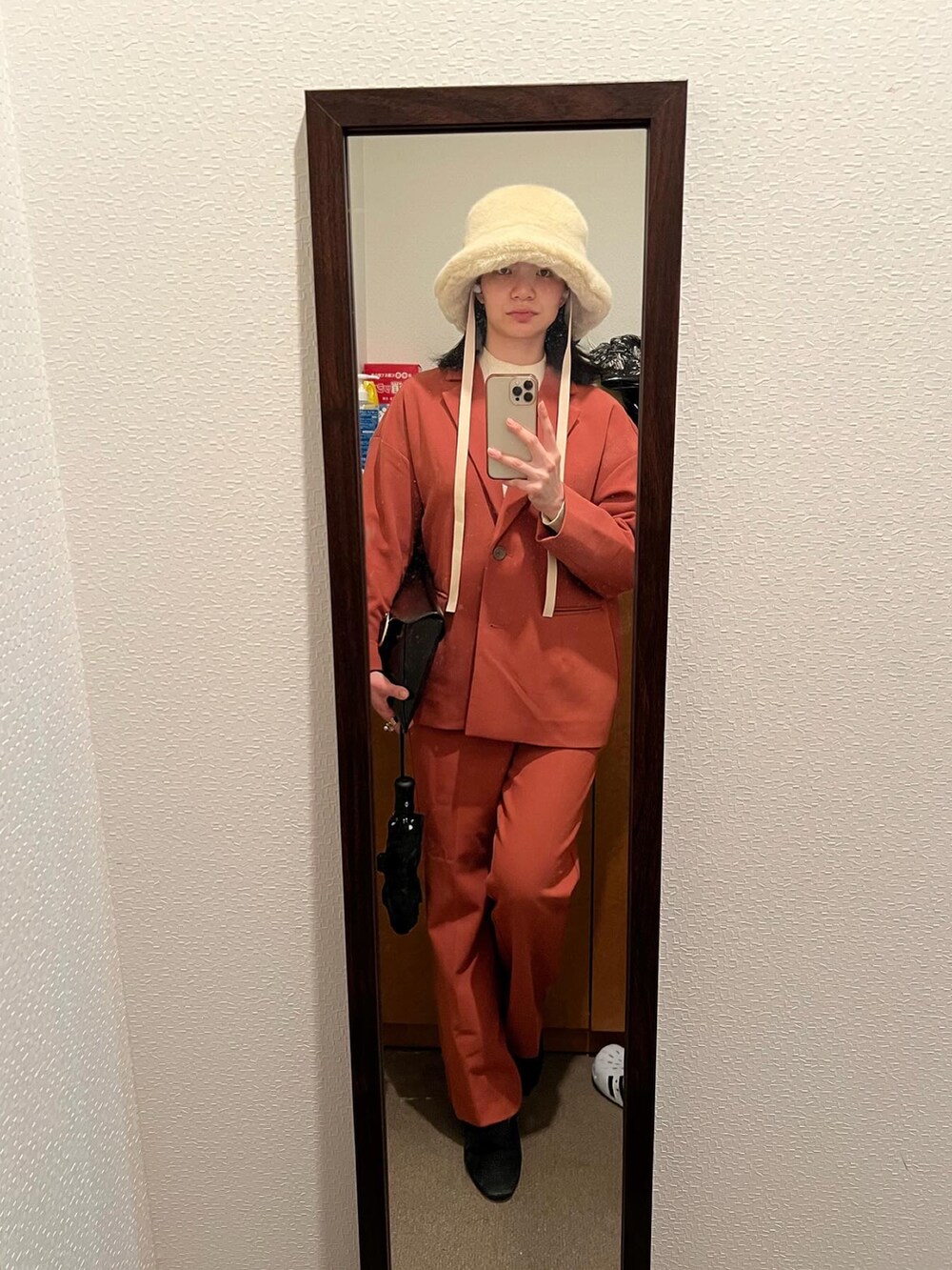 オレンジ系のテーラードジャケット、オレンジ系のその他パンツ、ブラック系のブーツを着用したレディースの春コーディネートの2枚目の写真