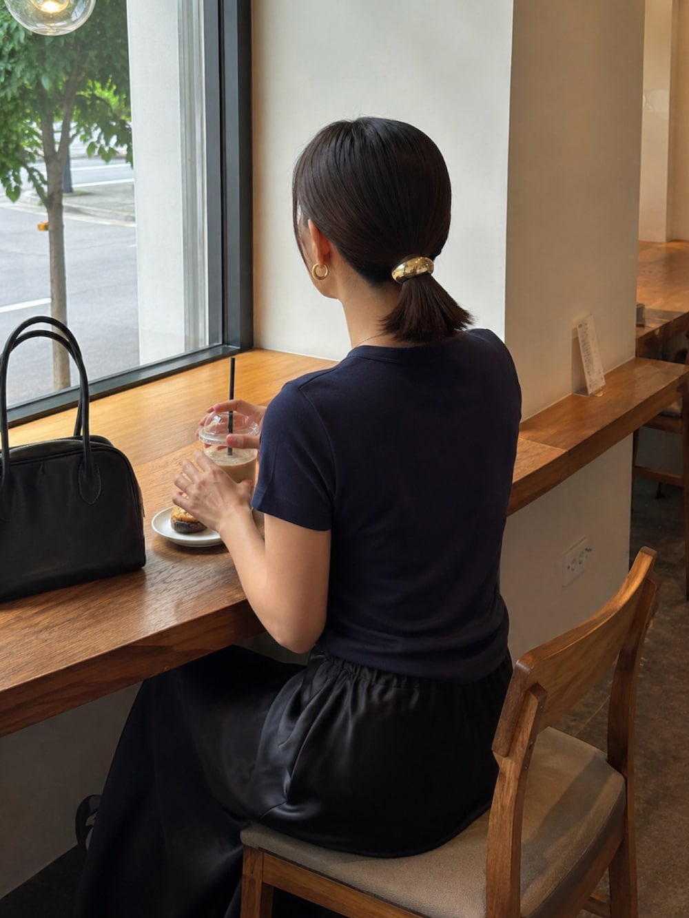 ホワイト系のスニーカー、ブラック系のスカート、ブルー系のTシャツ/カットソーを着用したレディースの夏コーディネートの2枚目の写真