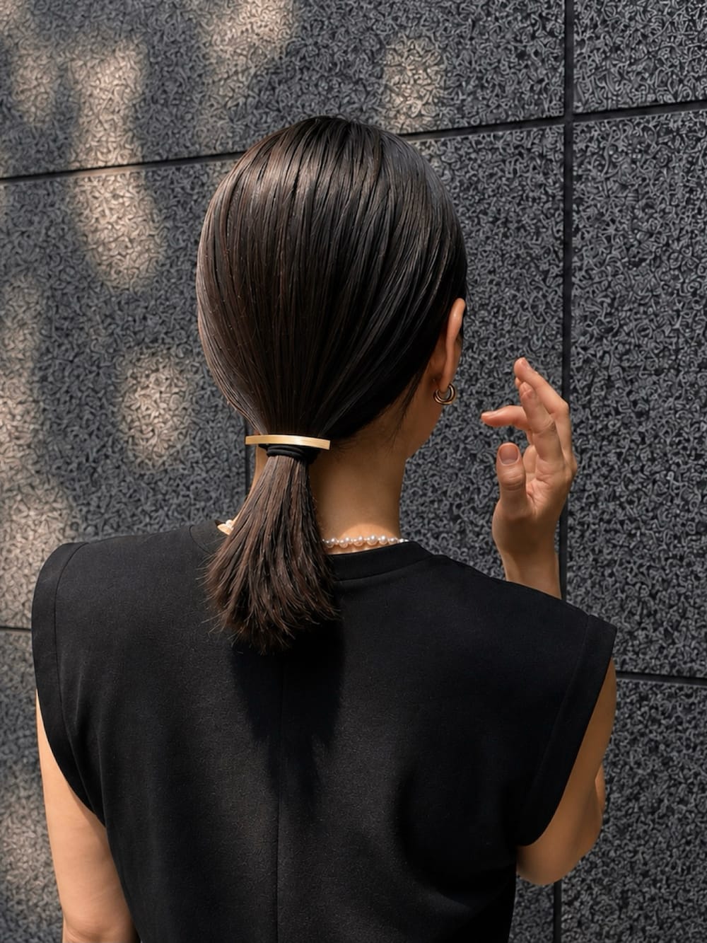 ホワイト系のパンツ、ブラック系のサンダル、ゴールド系のヘアゴムを着用したレディースの夏コーディネートの4枚目の写真