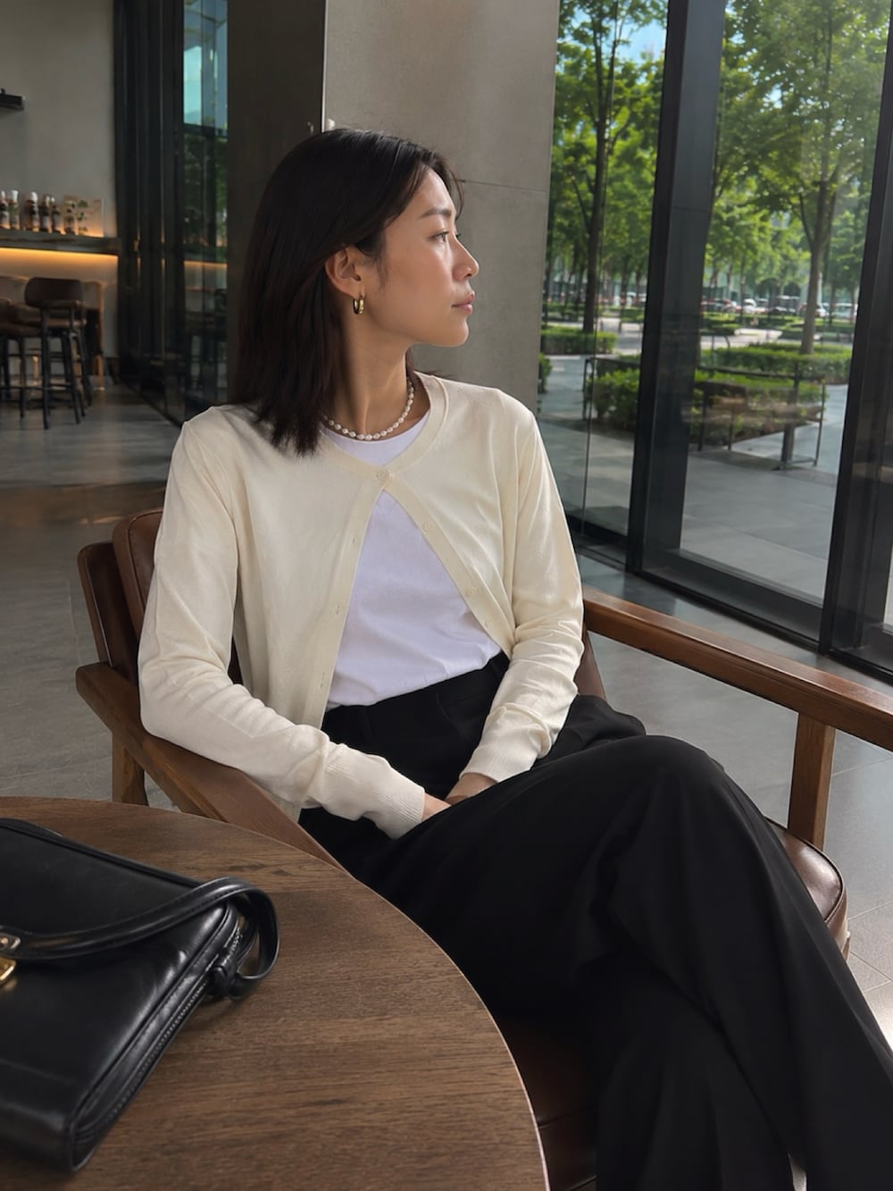 ホワイト系のTシャツ/カットソー、ホワイト系のカーディガン/ボレロ、ブラック系のスラックスを着用したレディースの夏コーディネートの3枚目の写真