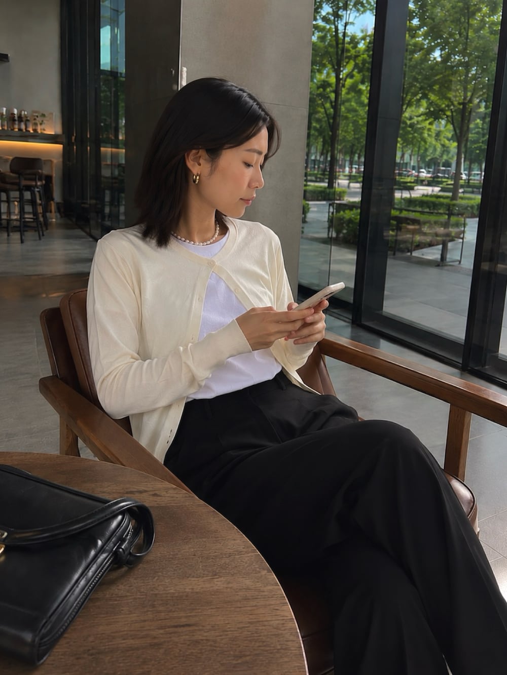ホワイト系のTシャツ/カットソー、ホワイト系のカーディガン/ボレロ、ブラック系のスラックスを着用したレディースの夏コーディネートの5枚目の写真