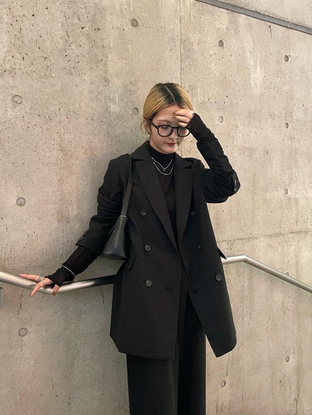 ブラック系のテーラードジャケット、ブラック系のスラックス、ブラック系のTシャツ/カットソーを着用したレディースの秋コーディネートの2枚目の写真