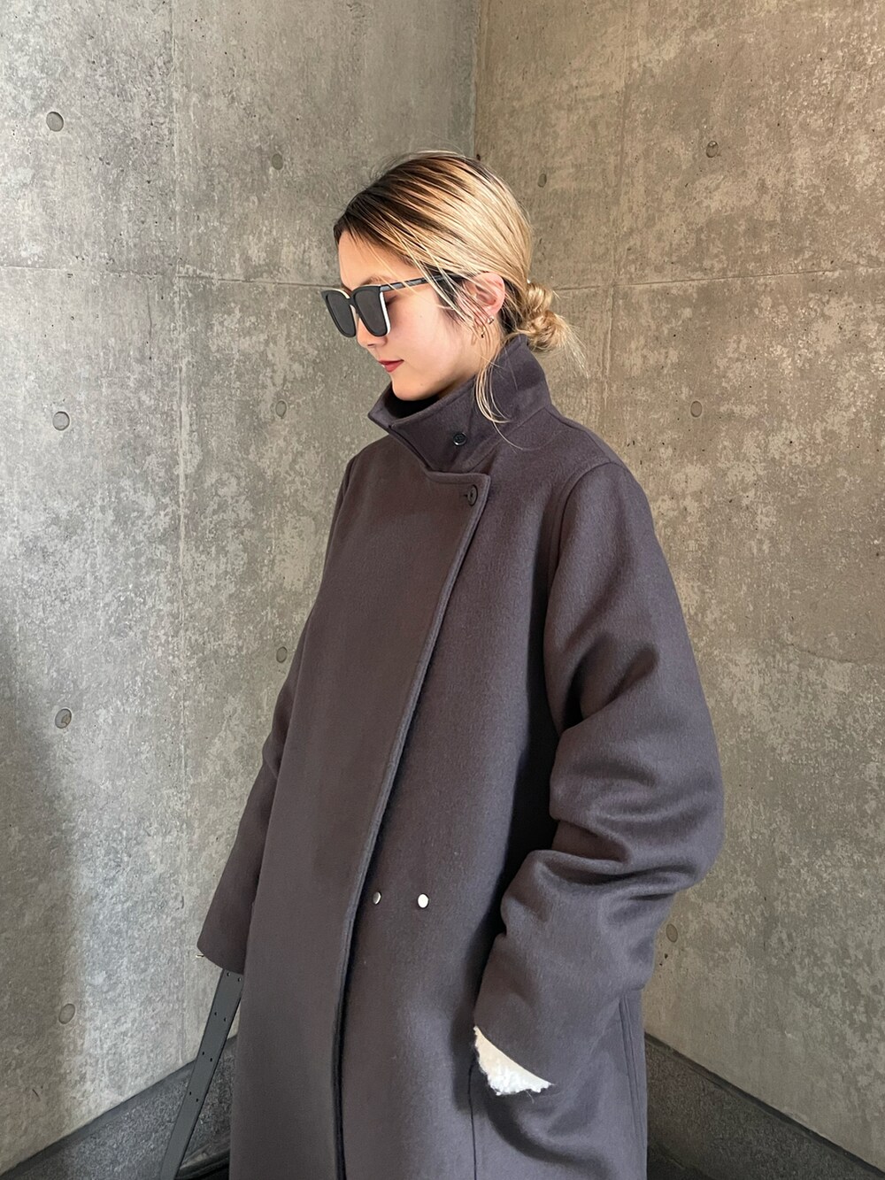 グレー系のチェスターコート、ベージュ系のスラックスを着用したレディースの冬コーディネートの2枚目の写真