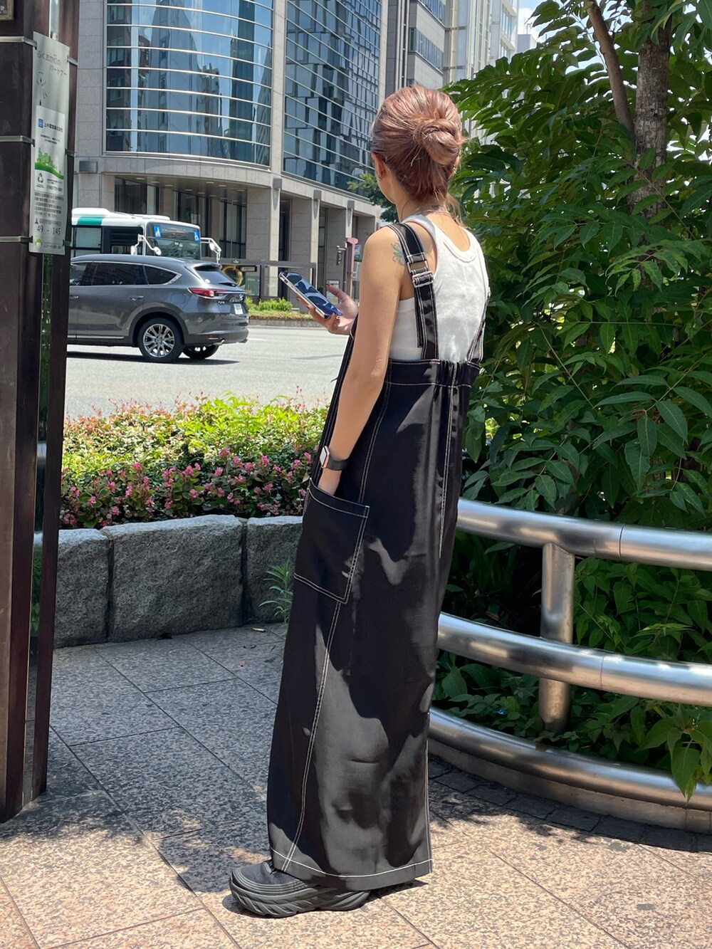 ブラック系のワンピース、ブラック系のバッグ、ブラック系のサングラスを着用したレディースの夏コーディネートの3枚目の写真