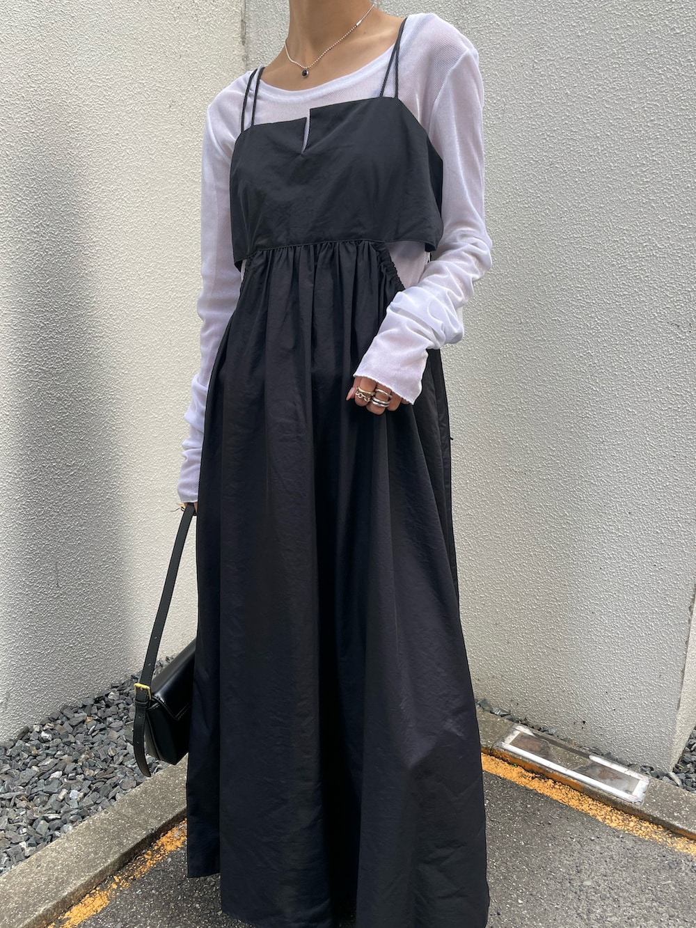 ブラック系のワンピース、ホワイト系のTシャツ/カットソー、ブラック系のショルダーバッグを着用したレディースの冬コーディネートの3枚目の写真