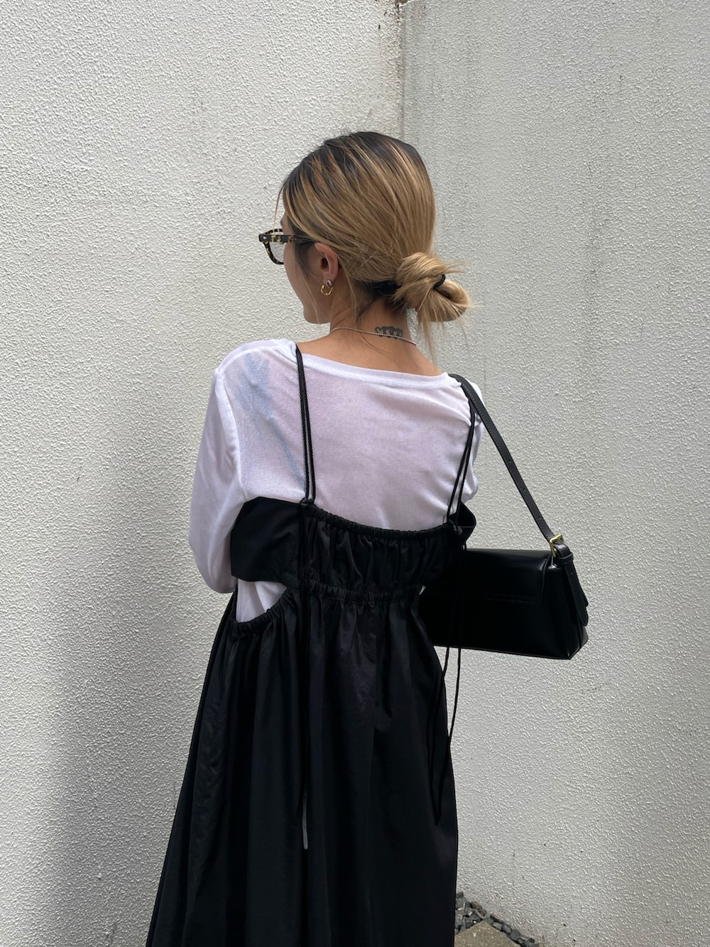 ブラック系のワンピース、ホワイト系のTシャツ/カットソー、ブラック系のショルダーバッグを着用したレディースの冬コーディネートの2枚目の写真