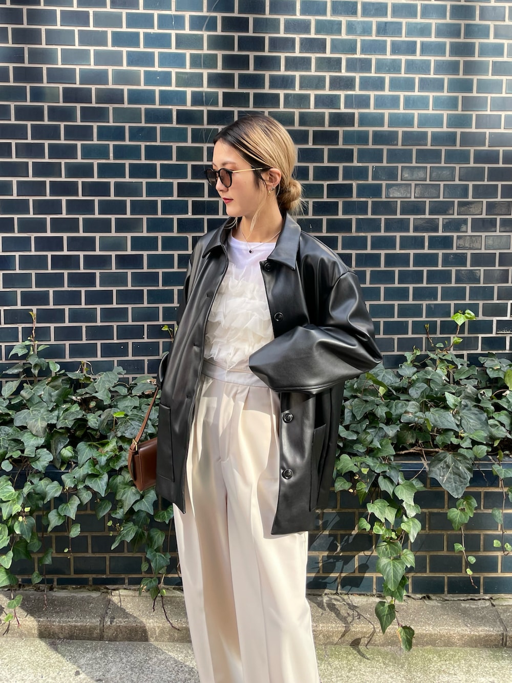 ブラック系のカバーオール、ホワイト系のベスト、ホワイト系のその他パンツを着用したレディースの冬コーディネートの2枚目の写真