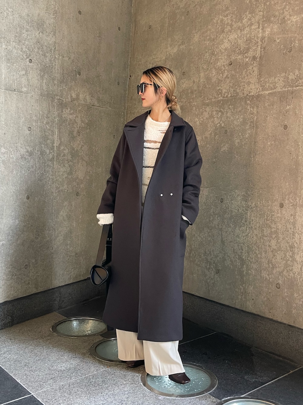 グレー系のチェスターコート、ベージュ系のスラックスを着用したレディースの冬コーディネートの3枚目の写真