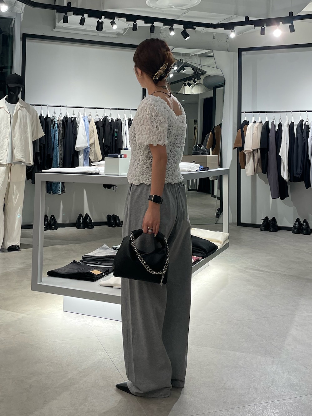 ホワイト系のTシャツ/カットソー、グレー系のスラックス、ブラック系のショルダーバッグを着用したレディースの夏コーディネートの2枚目の写真