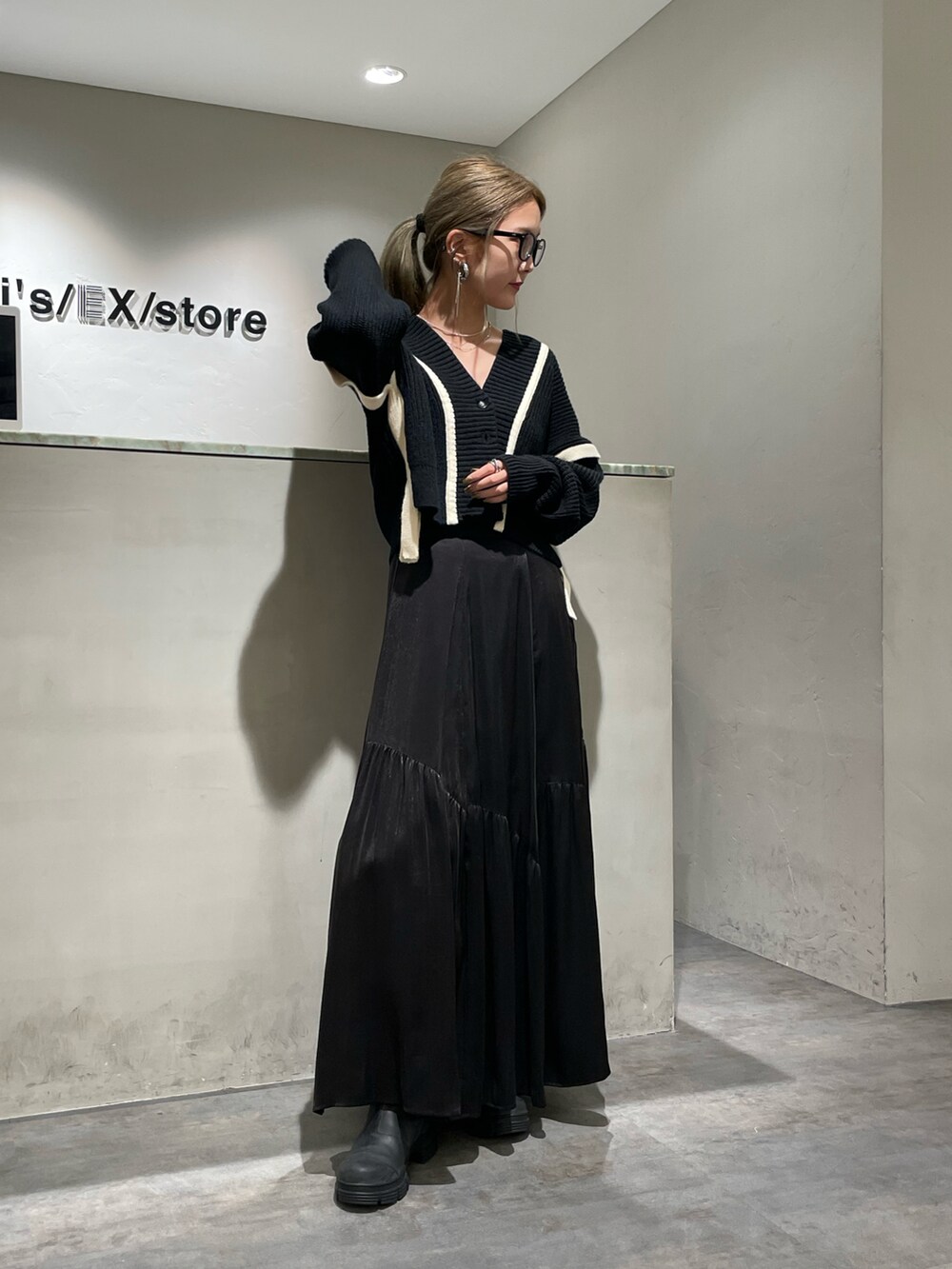 ブラック系のスカート、ブラック系のカーディガン/ボレロを着用したレディースの秋コーディネートの2枚目の写真
