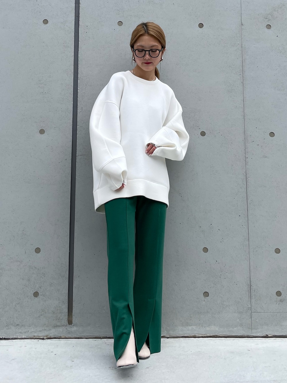 ホワイト系のTシャツ/カットソー、グリーン系のスラックス、ホワイト系のブーツを着用したレディースの冬コーディネートの2枚目の写真