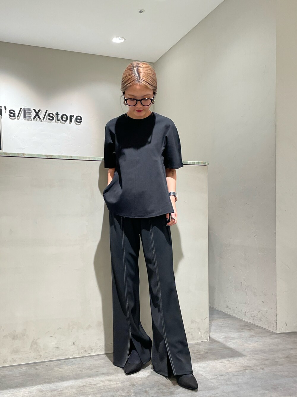 ブラック系のTシャツ/カットソー、ブラック系のスラックスを着用したレディースの夏コーディネートの2枚目の写真