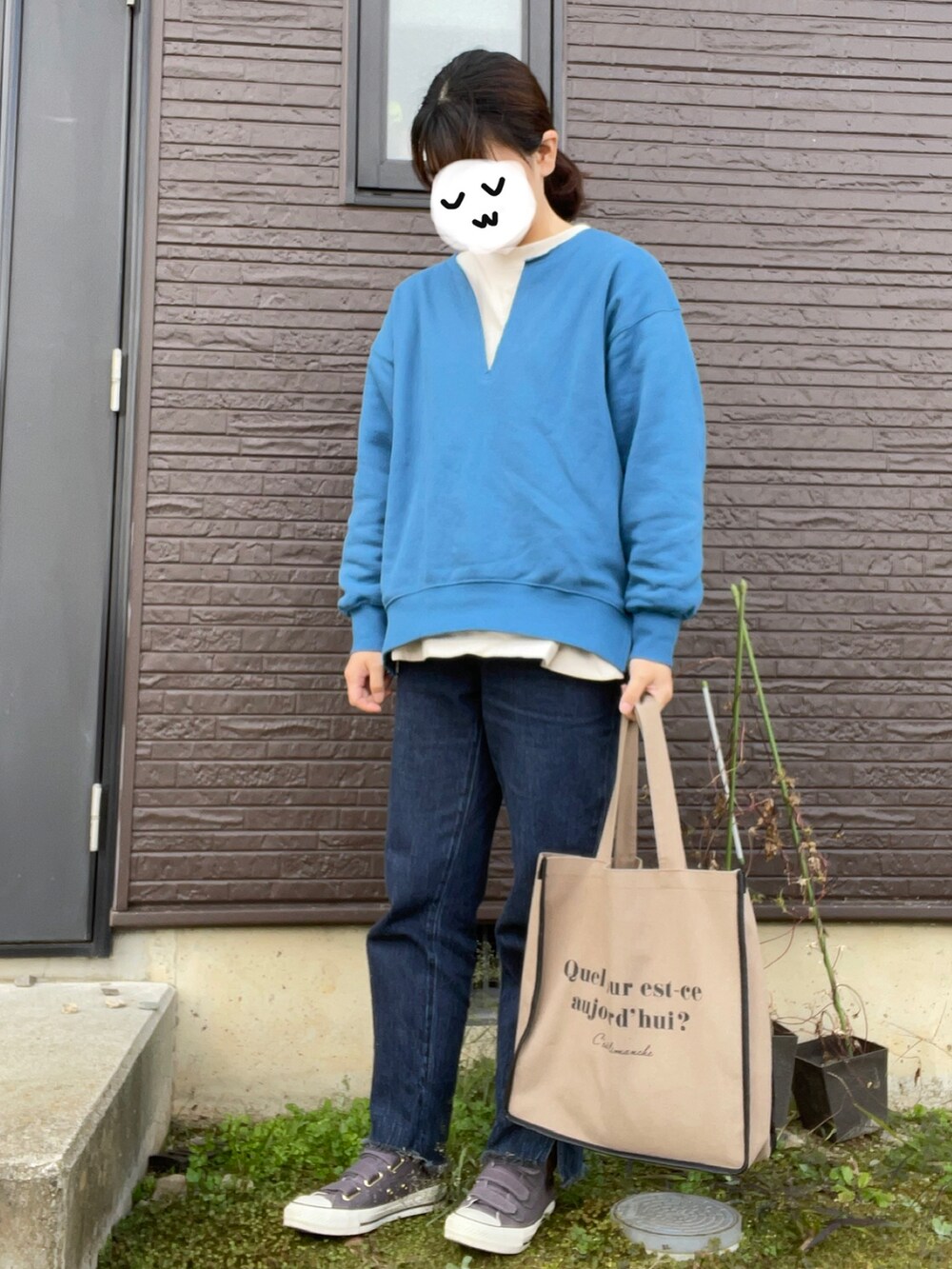 ブルー系のデニムパンツ、ブルー系のスウェット、ブラウン系のトートバッグを着用したレディースの秋コーディネートの2枚目の写真