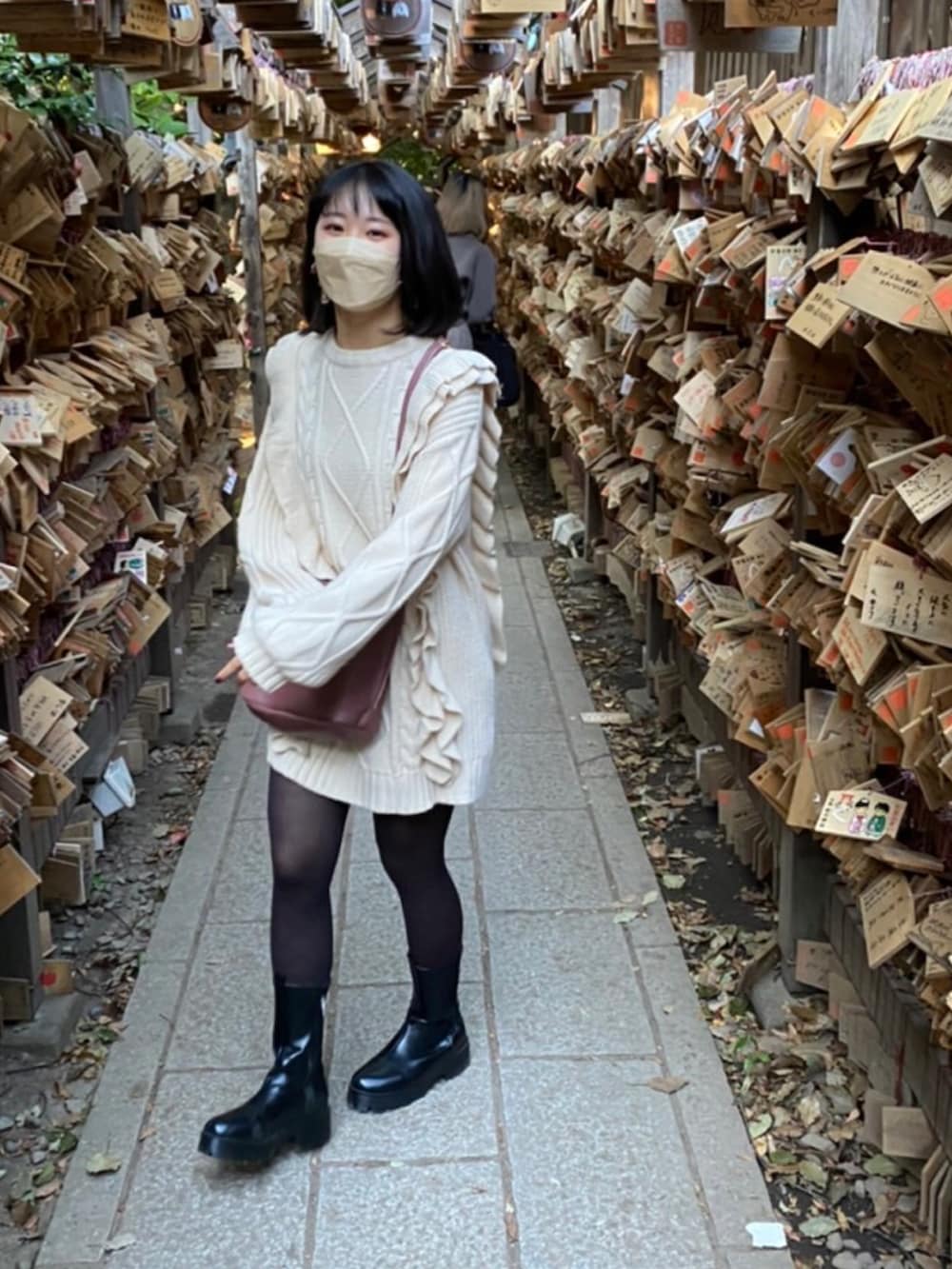 ホワイト系のニット/セーター、ピンク系のショルダーバッグ、ブラック系のブーツを着用したレディースの秋コーディネートの2枚目の写真