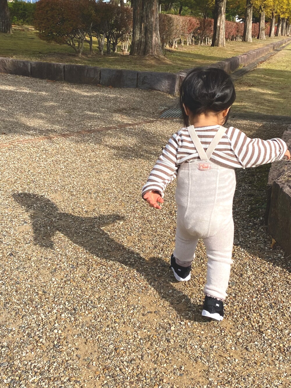 ブラック系のスニーカーを着用したキッズの秋コーディネートの2枚目の写真