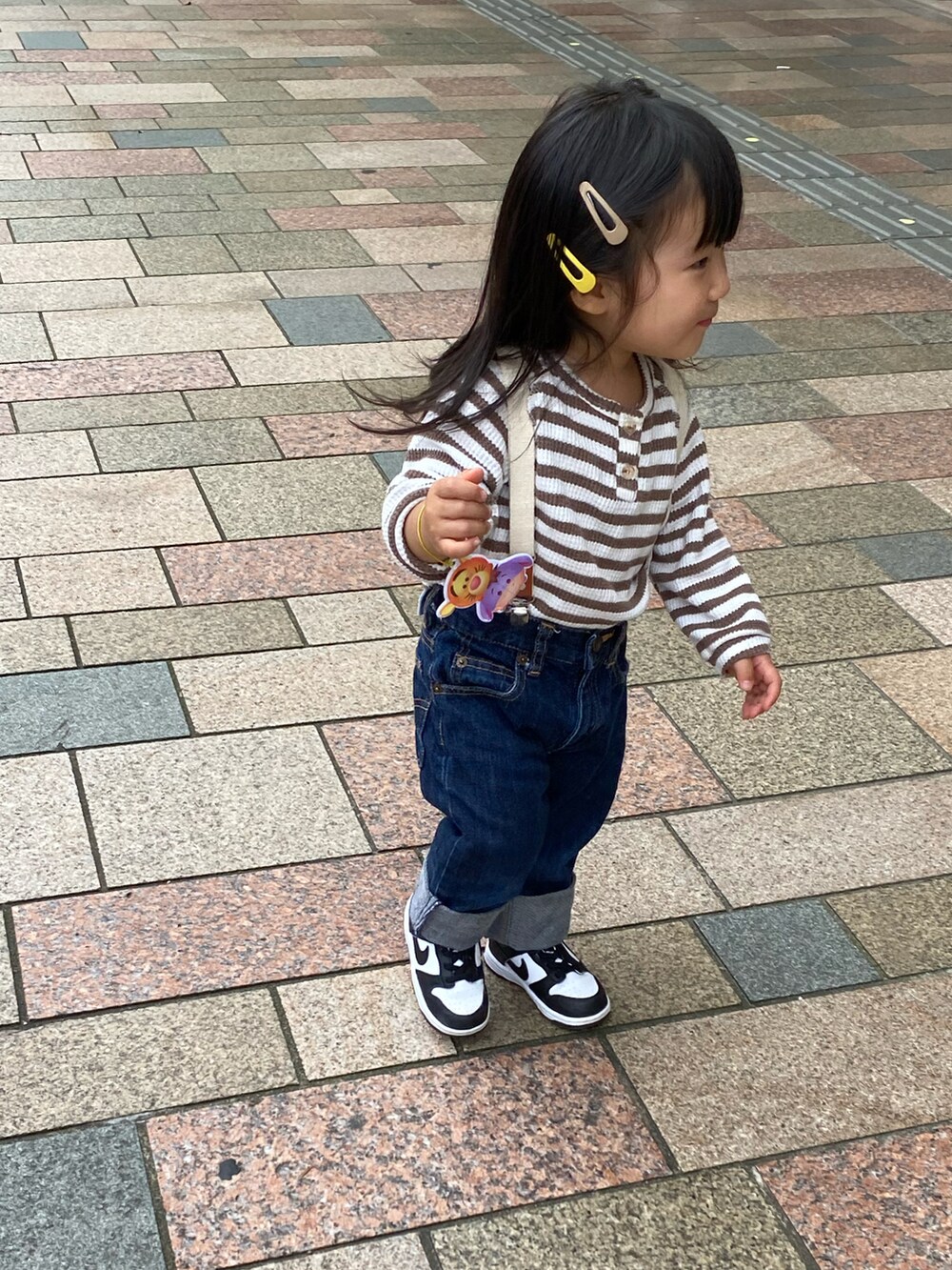 ブルー系のデニムパンツ、ブラウン系のTシャツ/カットソー、ブラック系のスニーカーを着用したキッズの秋コーディネートの2枚目の写真