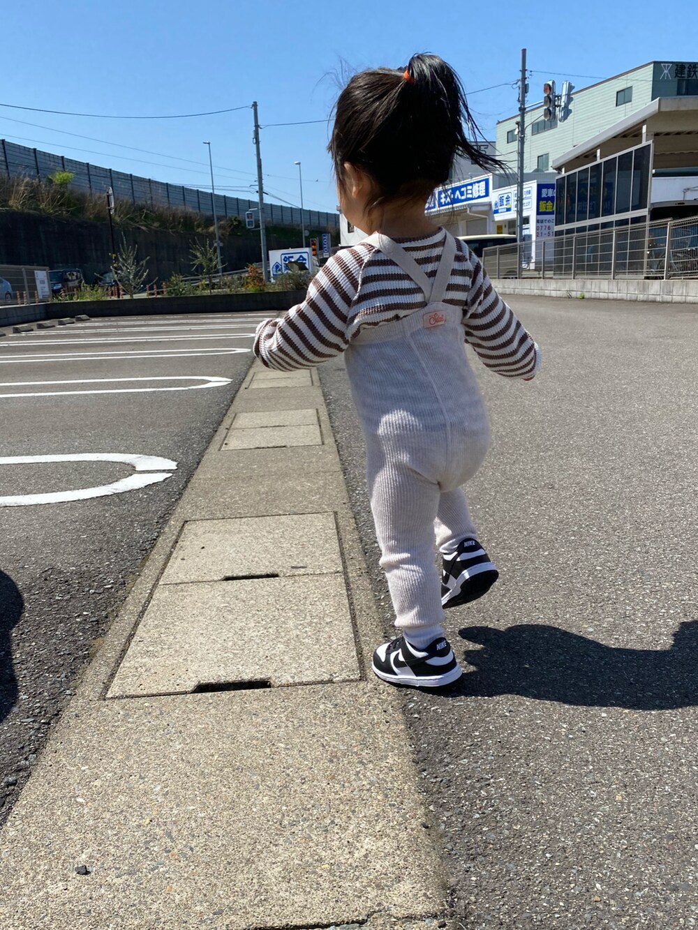 ブラック系のスニーカーを着用したキッズの春コーディネートの2枚目の写真