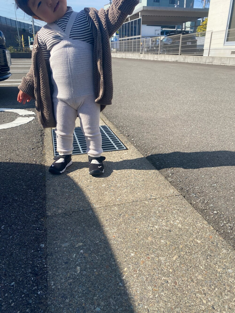 ブラウン系のカーディガン/ボレロ、ブラック系のスニーカーを着用したキッズの春コーディネートの3枚目の写真