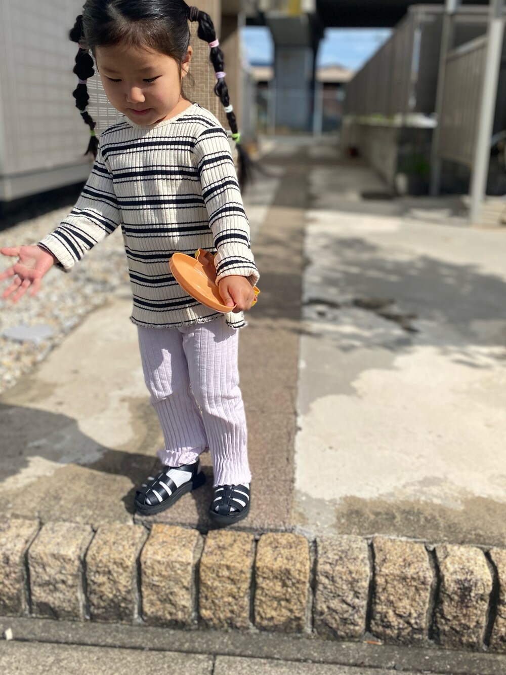 ホワイト系のTシャツ/カットソー、ピンク系のパンツ、ブラック系のサンダルを着用したキッズの秋コーディネートの2枚目の写真