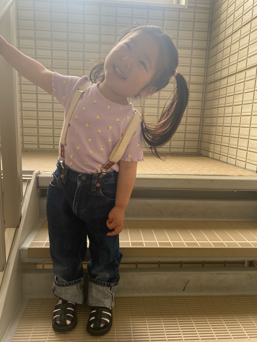 ブルー系のデニムパンツ、ブラック系のサンダル、ピンク系のTシャツ/カットソーを着用したキッズの春コーディネートの2枚目の写真