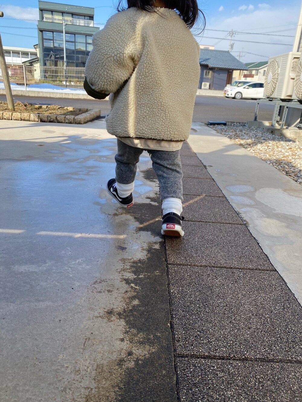 グレー系のパンツ、ブラック系のスニーカー、ホワイト系のファッション雑貨を着用したキッズの冬コーディネートの2枚目の写真