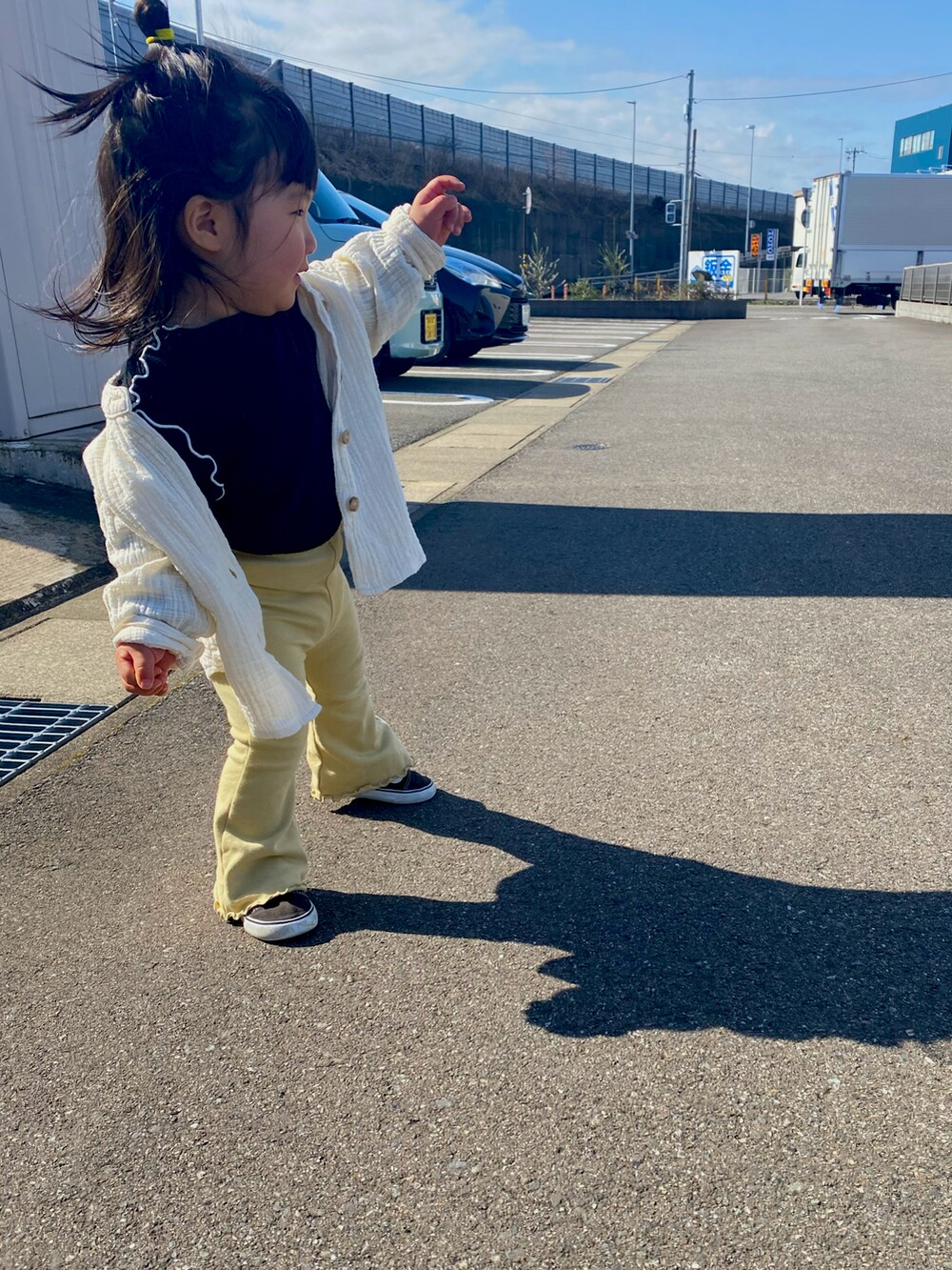 イエロー系のパンツ、ブラック系のTシャツ/カットソー、ブラック系のスニーカーを着用したキッズの春コーディネートの2枚目の写真