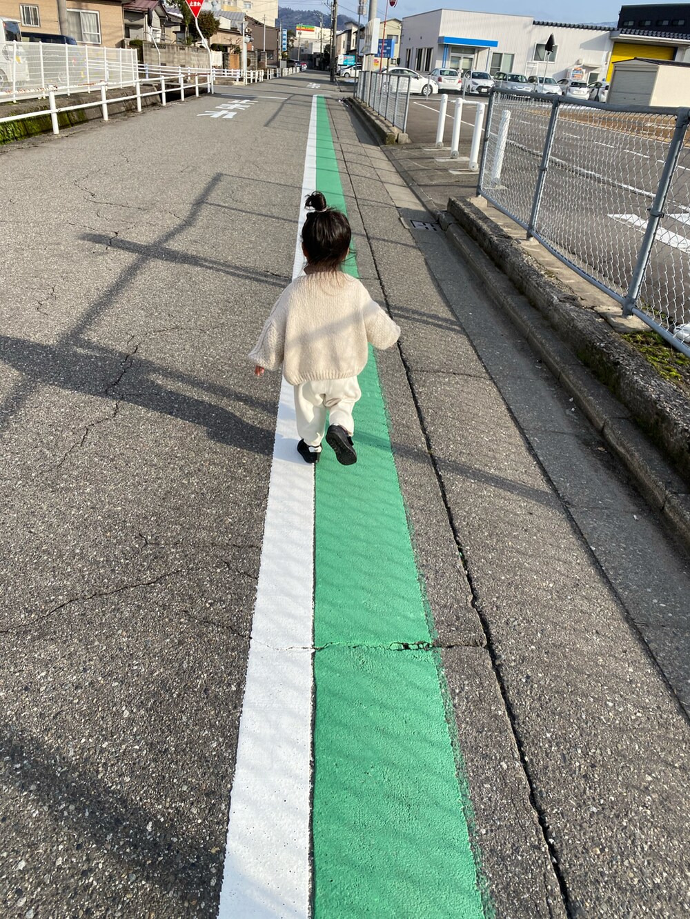 ベージュ系のカーディガン/ボレロ、ホワイト系のパンツ、ブラック系のスニーカーを着用したキッズの冬コーディネートの3枚目の写真
