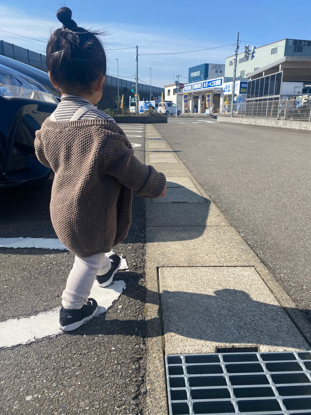 ブラウン系のカーディガン/ボレロ、ブラック系のスニーカーを着用したキッズの春コーディネートの2枚目の写真
