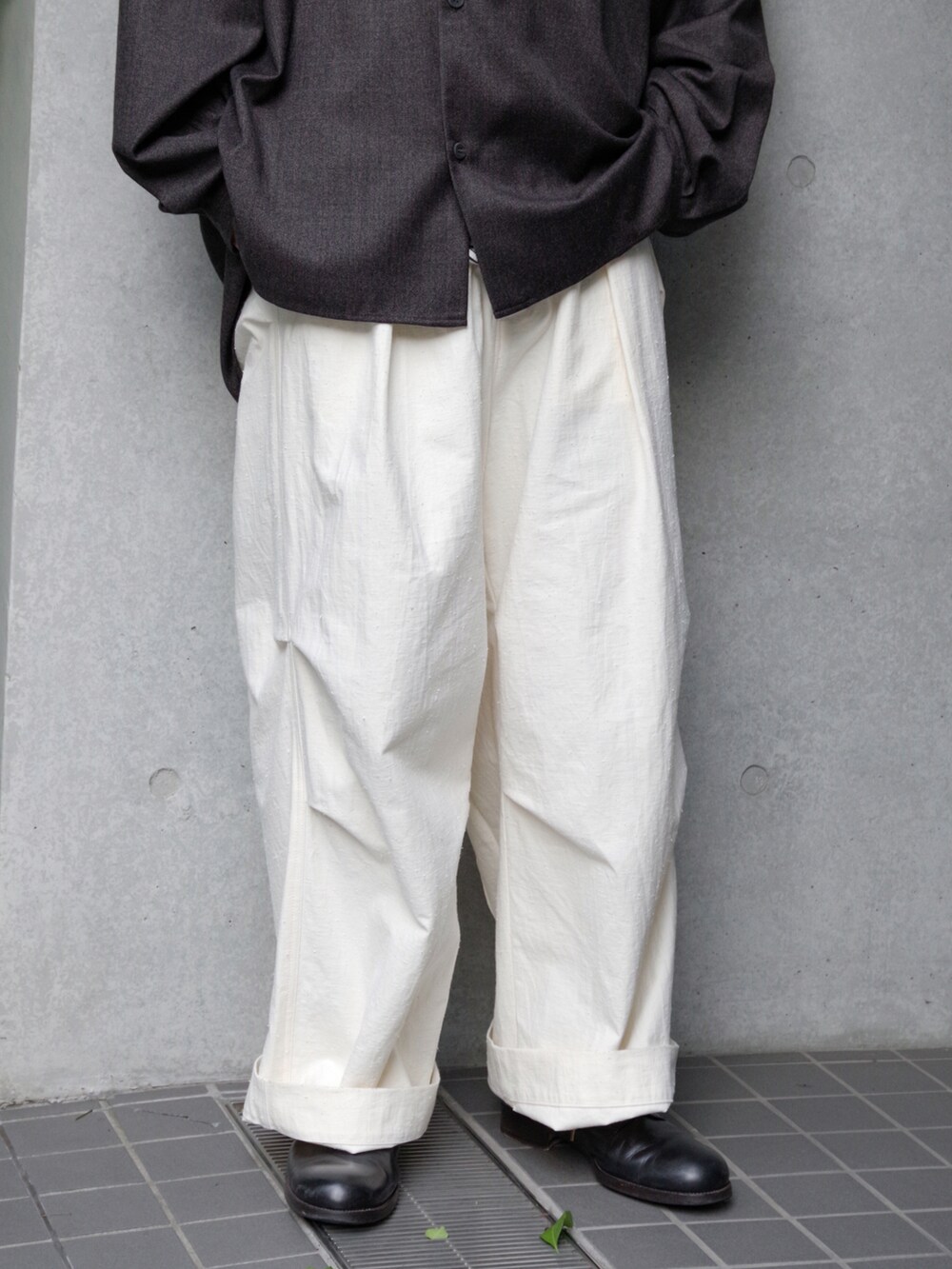 ホワイト系のパンツ、ブラック系のドレスシューズ、ブラウン系のシャツ/ブラウスを着用したメンズの秋コーディネートの3枚目の写真