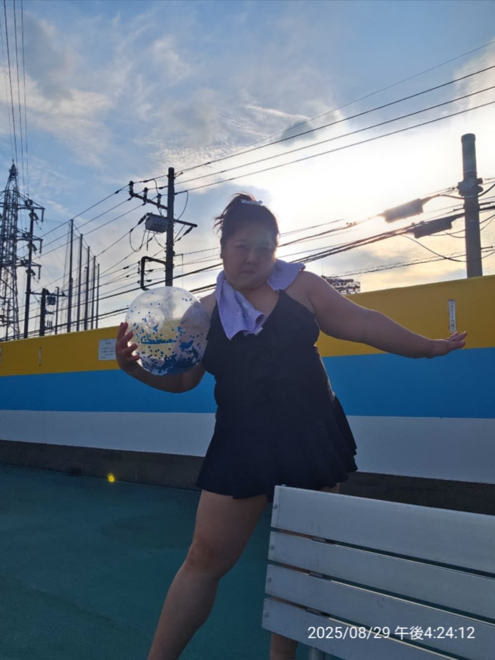 ブラック系のビーチサンダル、ブラック系の水着、パープル系のフェイスタオルを着用したレディースの夏コーディネートの5枚目の写真