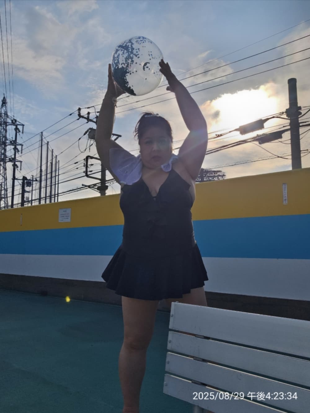 ブラック系のビーチサンダル、ブラック系の水着、パープル系のフェイスタオルを着用したレディースの夏コーディネートの2枚目の写真