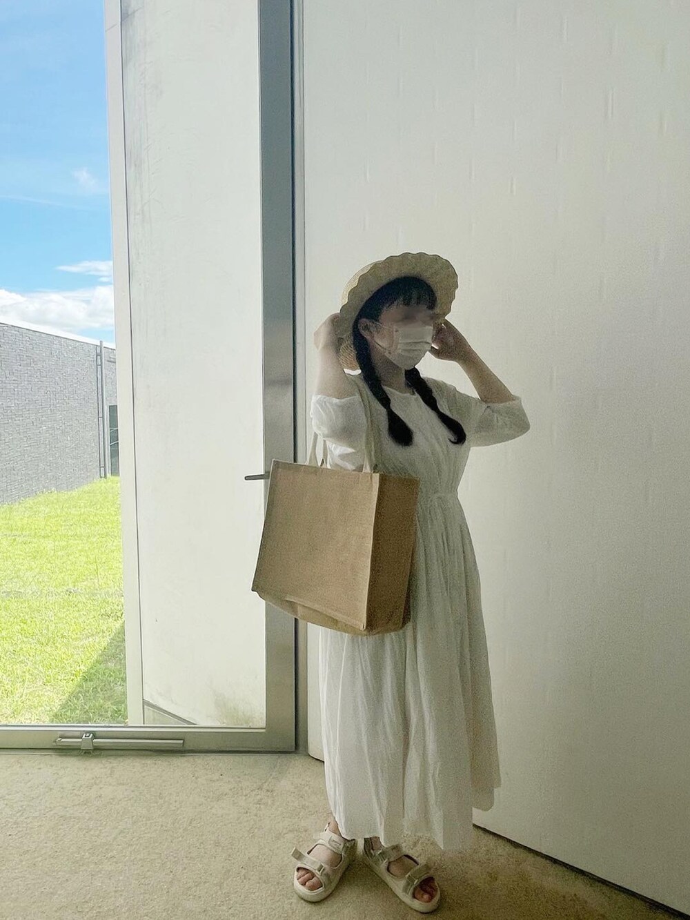 ホワイト系のワンピース、ベージュ系のバッグ、ホワイト系のハットを着用したレディースの秋コーディネートの3枚目の写真