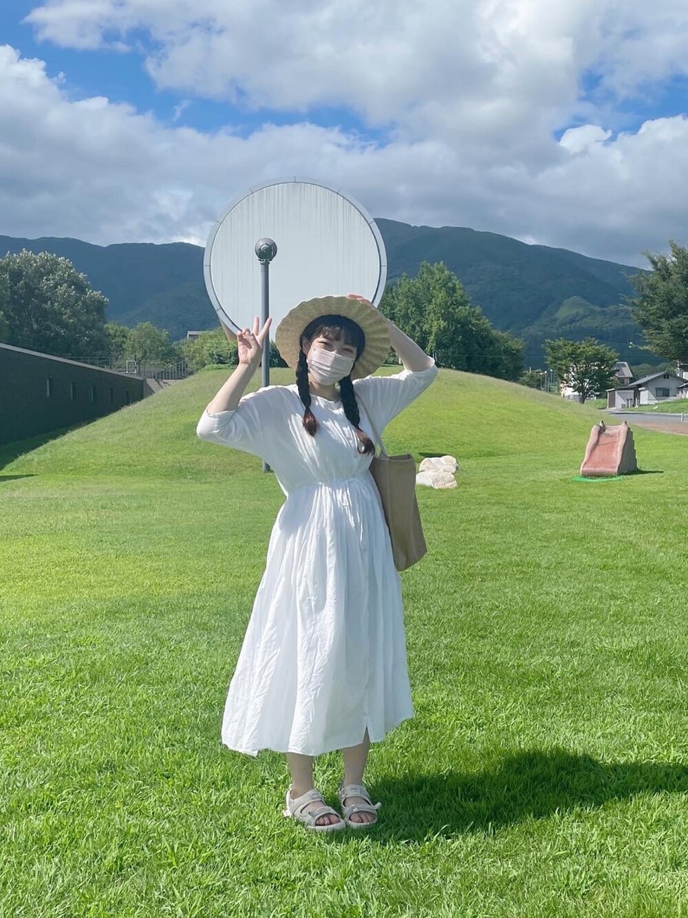 ホワイト系のワンピース、ベージュ系のバッグ、ホワイト系のハットを着用したレディースの秋コーディネートの4枚目の写真