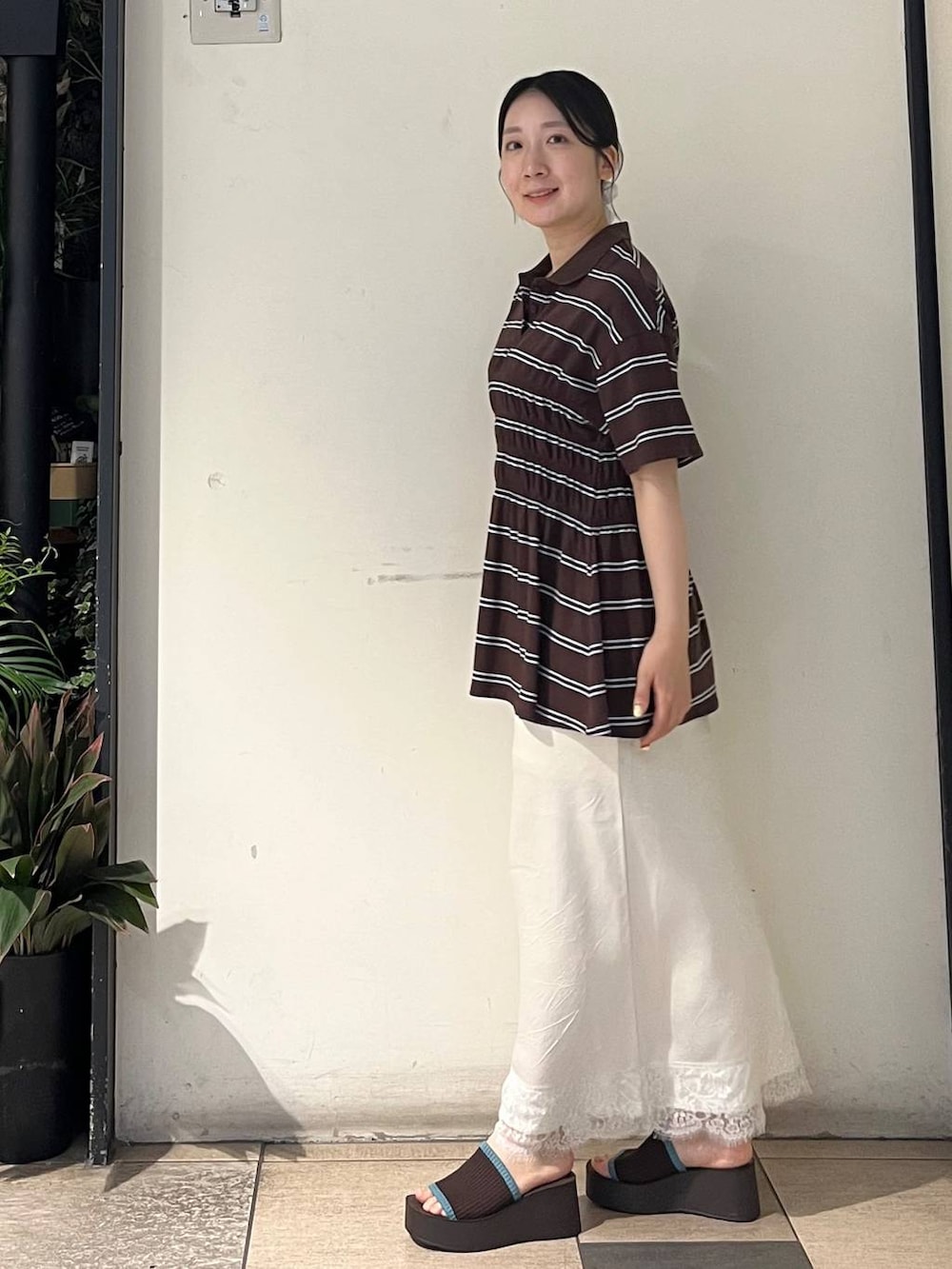 ブラウン系のサンダル、ホワイト系のスカート、ブラウン系のTシャツ/カットソーを着用したレディースの夏コーディネートの3枚目の写真