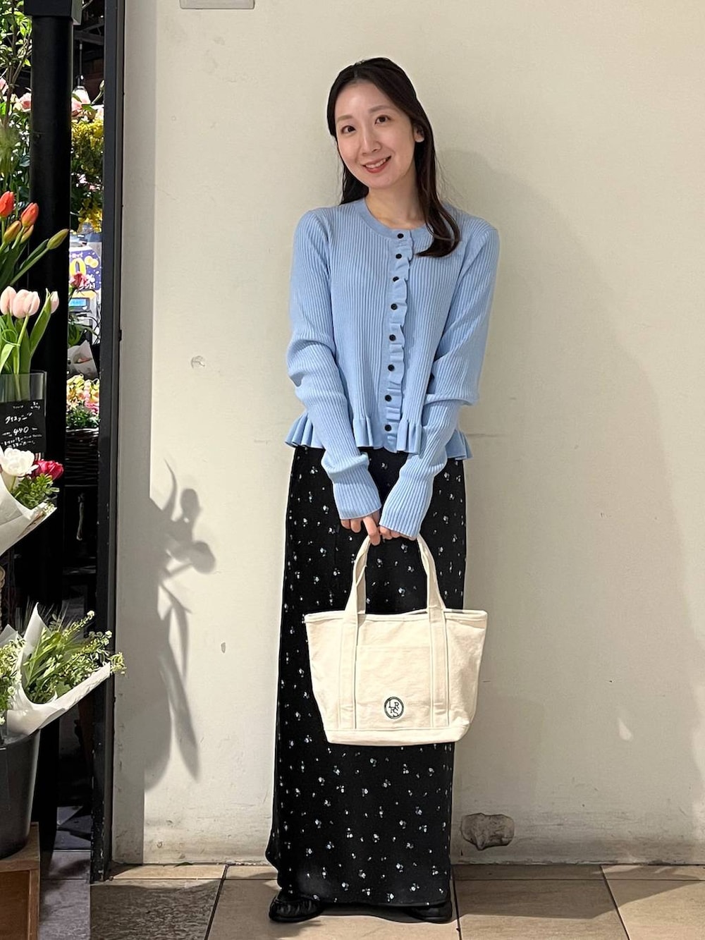 ブラック系のスカート、ホワイト系のショルダーバッグ、ブルー系のTシャツ/カットソーを着用したレディースの冬コーディネートの5枚目の写真