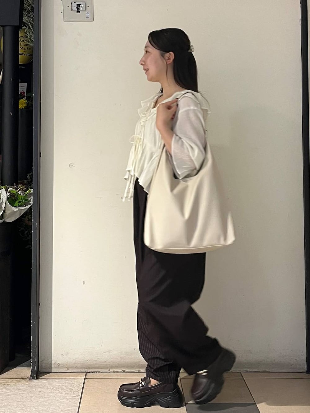 ホワイト系のショルダーバッグ、シルバー系のタンクトップ、ブラウン系のその他パンツを着用したレディースの夏コーディネートの3枚目の写真