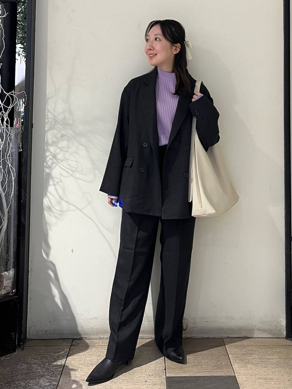 ホワイト系のショルダーバッグ、グレー系のテーラードジャケット、グレー系のその他パンツを着用したレディースの秋コーディネートの2枚目の写真