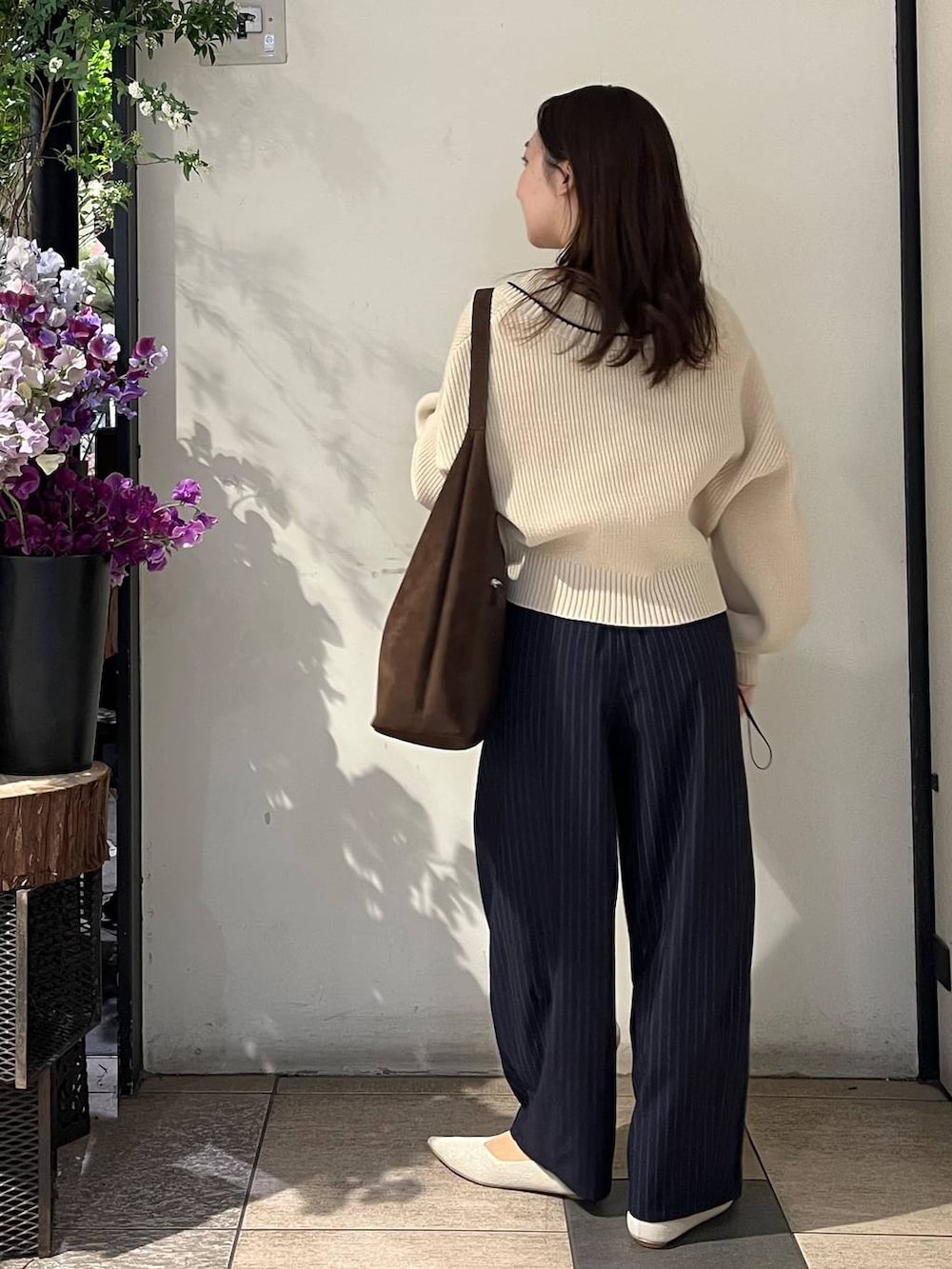 ブラウン系のショルダーバッグ、ブルー系のその他パンツ、ホワイト系のカーディガン/ボレロを着用したレディースの冬コーディネートの4枚目の写真